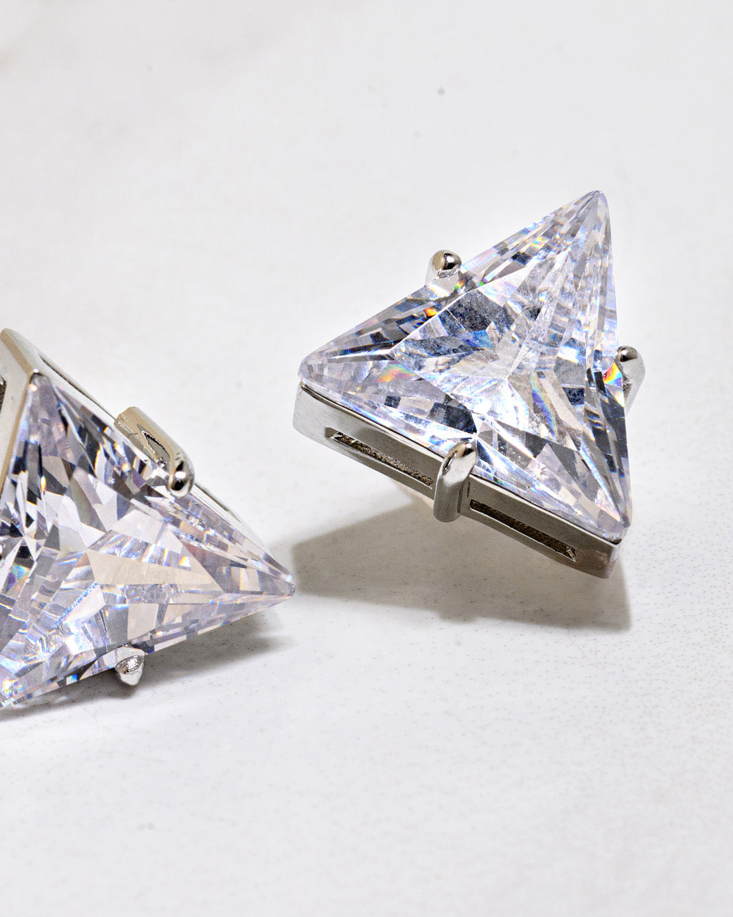 Large Silver and Cubic Zirconia Statement Stud Earrings. Gold pyramid-shaped cubic zirconia stud earrings with a 18K gold finish and secure post-back closure. Hypoallergenic and nickel-free.